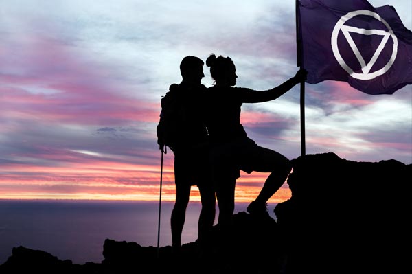 Two people raise the Audify Flag on top a mountain top as pioneers in hearing care